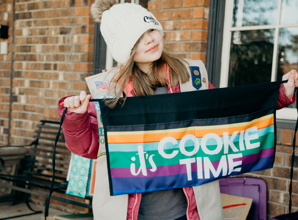 Girl Scout holding an "it's COOKIE TIME" sign