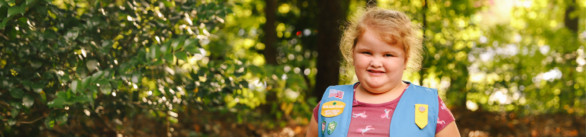  small girl in pink unicorn dress in a daisy vest 