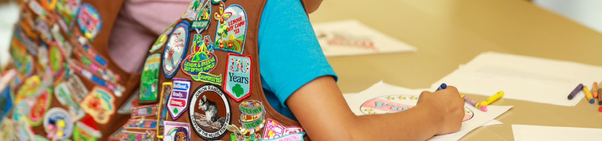  up-close photo of back of Brownie vest while girl colors 