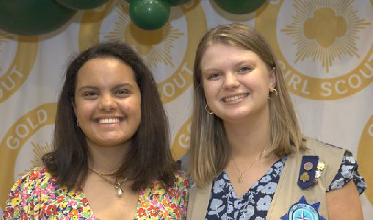 Gold Award Girl Scout smiling next to community partner