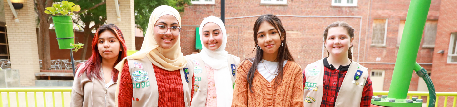  portrait of five Girl Scouts in front of a brick wall 