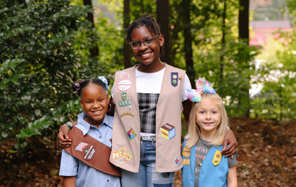 group of three Girl Scouts pose together