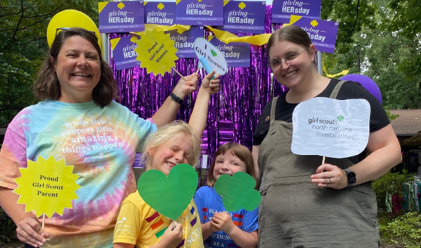 family posing in front of a photobooth backdrop